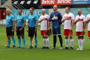 Polska reprezentacja śpiewa hymn, piłkarze trzymają ręce na sercach.