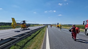 Autostrada i stojące na niej dwa śmigłowce.