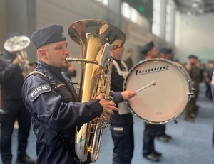 Na zdjęciu policjant grający na puzonie.