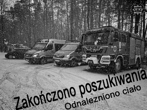 Na nocnym zdjęciu widzimy trójkę policjantów rozmawiajacych na tle pojazdów strażackich