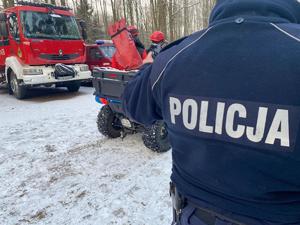 Na zdjęciu po prawej policjant w tle quad i pojazdy strażackie