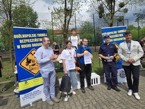 Grupa uczniów wraz z organizatorami trzymająca w rękach dyplomy i puchary - tuż po wręczeniu nagród