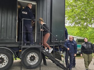 Mundurowi wchodzący do przyczepy ciężarówki