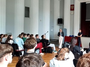 Na dużej sali siedzi grupa młodzieży podczas wykładów.