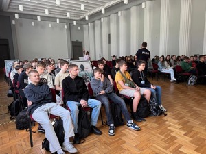 Na dużej sali siedzi grupa młodzieży podczas wykładów.