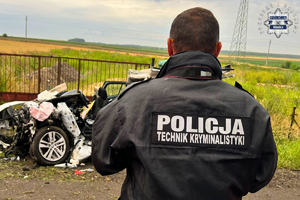 na zdjęciu policjant w kurtce z napisem policja kryminalistyka przed rozbitym pojazdem