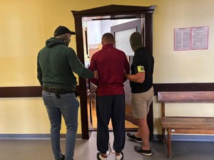 Do pokoju wprowadzany jest zatrzymany przez nieumundurowanych policjantów.
