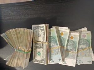 Na stole leżą 3 pliki banknotów.