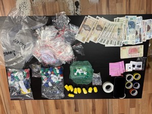 Na zdjęciu porozkładane na podłodze narkotyki w woreczkach, waga oraz pieniądze.