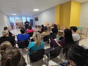 Umundurowany policjant prowadzi wykład dla pracowników szpitala w Pyskowicach.