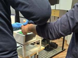 Pobieranie odcisków palców od zatrzymanego.