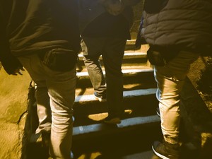 Dwóch policjantów prowadzi po scgodach zatrzymanego