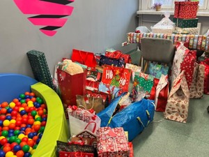 Na zdjęciu paczki świąteczne przygotowane dla dzieci z pieczy zastępczej w Gliwicach leżą gotowe na podłodze w pomieszczeniu Ośrodka Pomocy Społecznej.