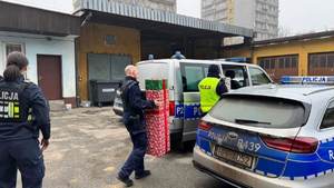 Policjanci wnoszą prezenty do radiowozu