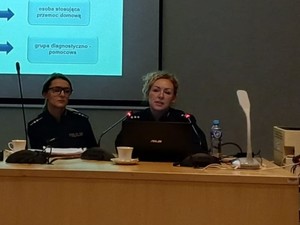 Dwie umundurowane policjantki prowadzą wykład. W tle prezentacja.