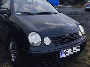 Pojazd koloru granatowego. W tle stoi radiowóz