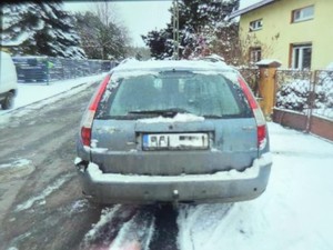 Na chodniku przy ulicy stoi pojazd.