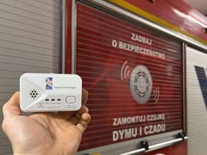 Czujnik czadu na tle pojazdu straży pożarnej.