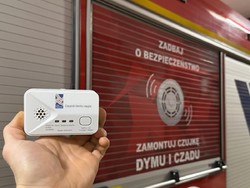 Czujnik czadu na tle pojazdu straży pożarnej.