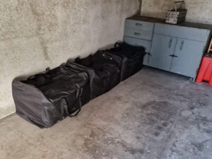 Na podłodze w pomieszczeniu stoją czarne torby z narkotykami.