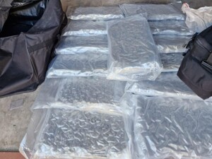 Na podłodze w opakowaniach leżą paczki narkotyków.