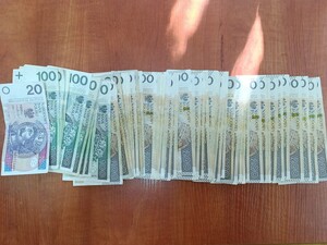 Na zdjęciu poukładane na stole w rzędzie banknoty pieniędzy.