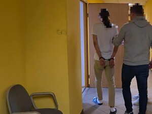 Policjant wprowadza do pomieszczenia zatrzymanego