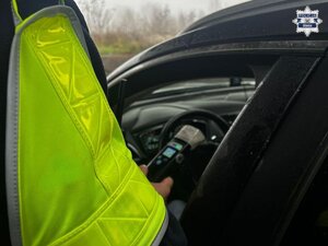 Na zdjęciu policjant badający trzeźwość kierowcy samochodu