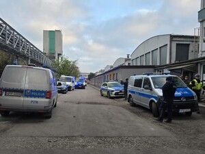 Radiowozy oznakowane policji stoją na terenie kopalni