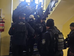 Policjanci po schodach wprowadzają zatrzymanych