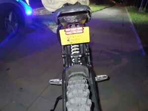 Na zdjęciu tył motocykla na tle radiowozu Policji
