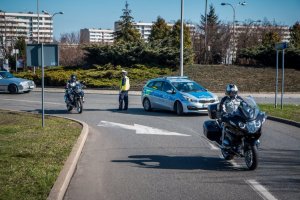 Fotografia kolorowa. Przedstawia uczestników przejazdu motocyklowego oraz policjantów zabezpieczających to wydarzenie.