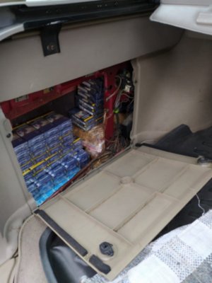 Zdjęcie kolorowe, przedstawiające zabezpieczone papierosy w samochodzie osobowym.