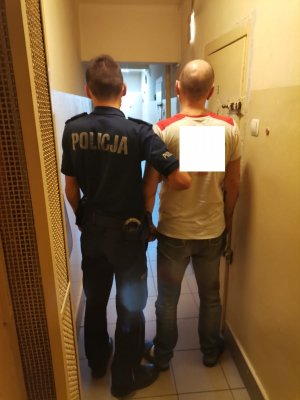 Zdjęcie przedstawiające policjanta oraz zatrzymanego.