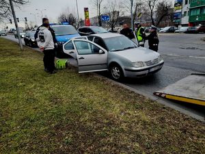 Zdjęcie osoby poszukiwanej, policjantów oraz pojazd vw.