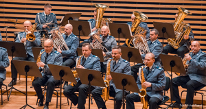 Zdjęcie przedstawiające policyjną orkiestrę grającą na Sali Koncertowej w Jastrzębiu-Zdroju, gdzie na pierwszym planie widać muzyków grających na saksofonach.