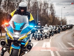 Zdjęcie przedstawiające uczestników rozpoczęcia sezonu oraz policjanta na motocyklu.