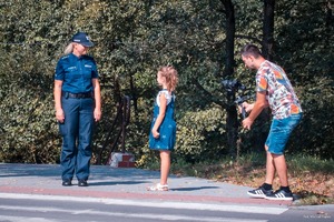 Zdjęcie przedstawiające policjantkę oraz dziewczynkę i Pana Lemańskiego - operatora kamery.