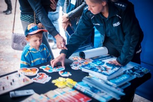 Zdjęcie przedstawiające policjantkę układającą puzzle wraz z chłopczykiem.