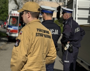 policjanci i strażak podczas zabezpieczenie terenu w miejscu zdarzenia