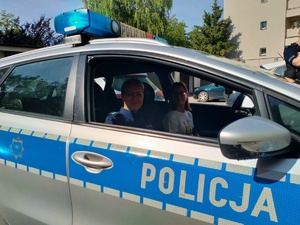 Zdjęcie przedstawiające Amelkę oraz policjantkę w radiowozie.