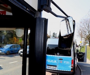 Zdjęcie części autobusu oraz radiowóz policyjny.