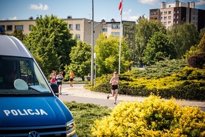 Zdjęcie radiowozu oraz biegaczek.