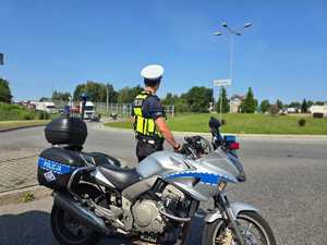 Zdjęcie przedstawiające Policjanta Ruchu Drogowego oraz motocykl.