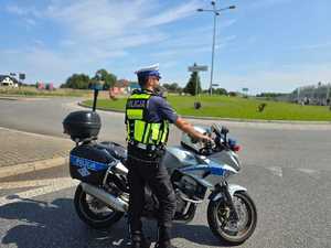 Zdjęcie przedstawiające Policjanta Ruchu Drogowego oraz motocykl.