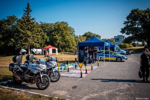 Zdjęcie motocykli oraz stoiska policyjnego.