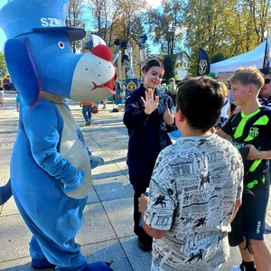 Zdjęcie przedstawiające Sznupka oraz uczennicę z klasy policyjnej oraz uczestników festiwalu.