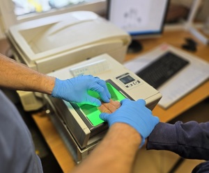 Zdjęcie przedstawiające moment pobierania odcisków linii papilarnych.