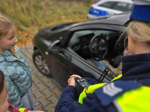 Zdjęcie policjanta oraz dzieci w trakcie kontroli drogowej.