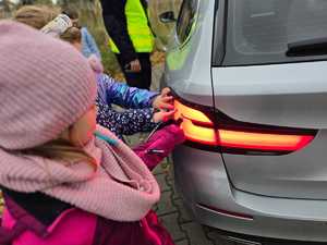 Zdjęcie policjanta oraz dzieci w trakcie kontroli drogowej.